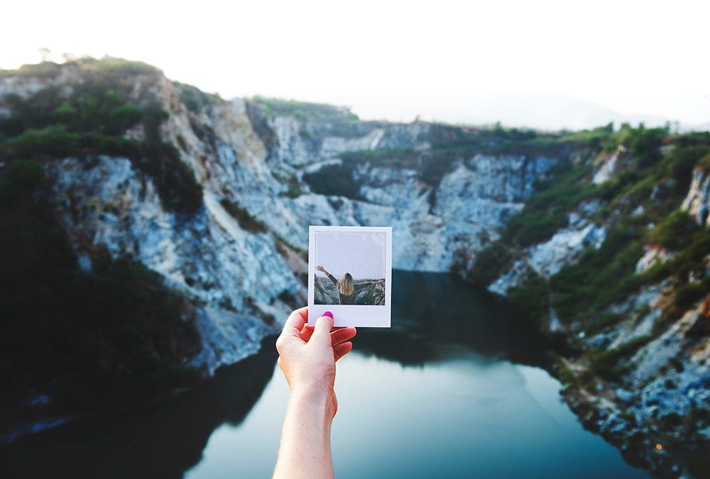 Holding a polaroid picture.